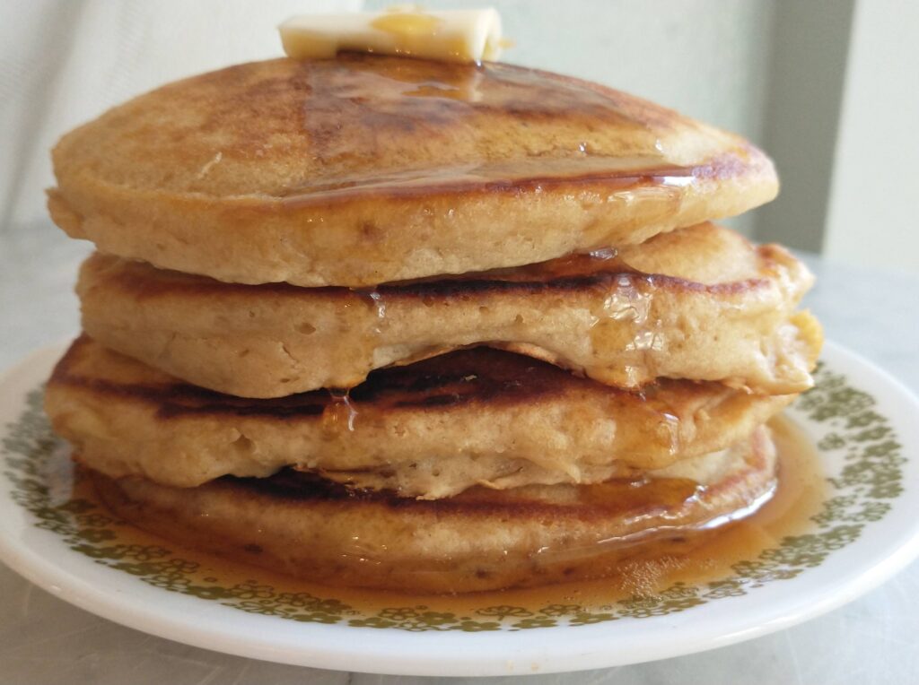 Fluffy pancakes with maple syrup and butter on top