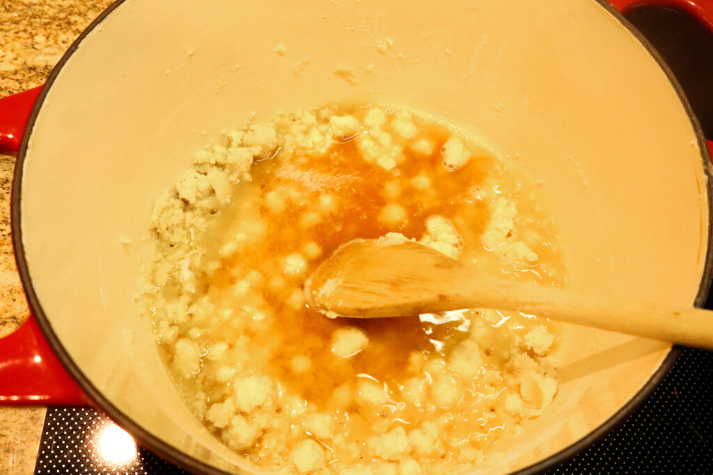 mixing the broth into the flour and butter