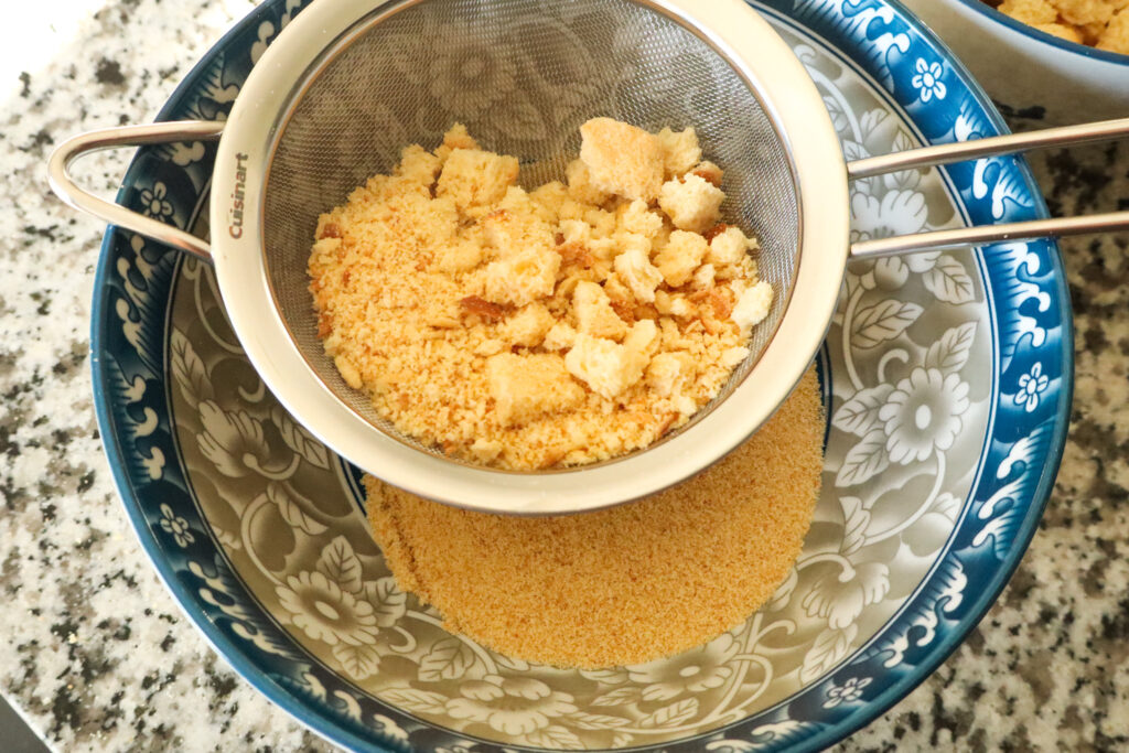 using a sieve to separate large chunks of bread from the crumbs