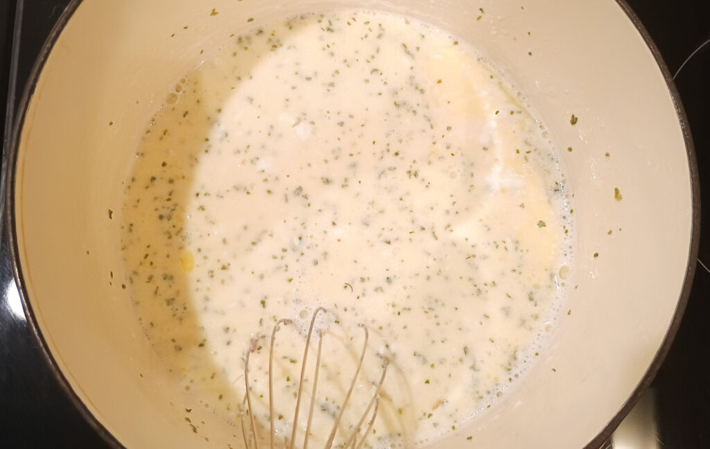 whisking the alfredo sauce