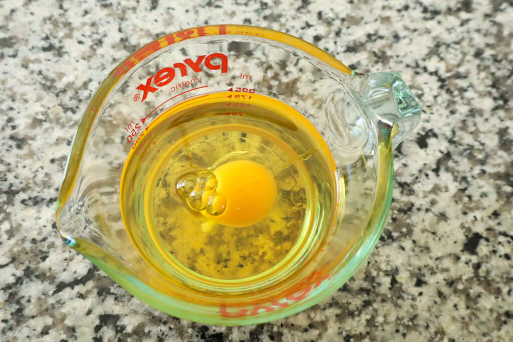 egg and oil in measuring cup