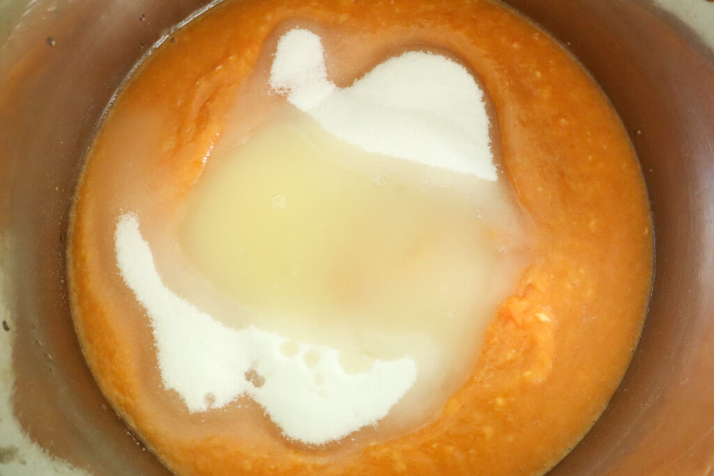 adding sugar and lemon juice for peach preserves