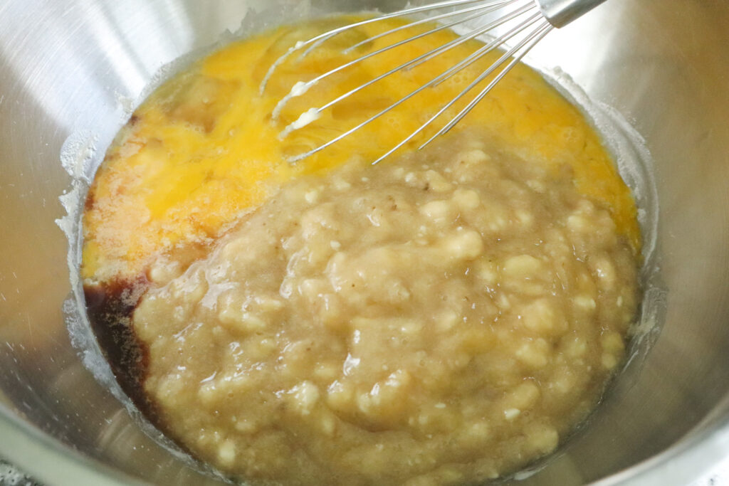 adding mashed bananas to banana bread batter