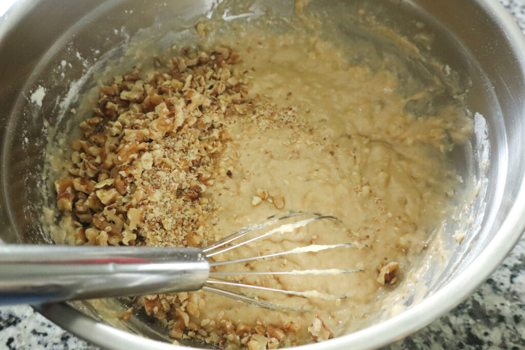 adding walnuts to banana bread batter