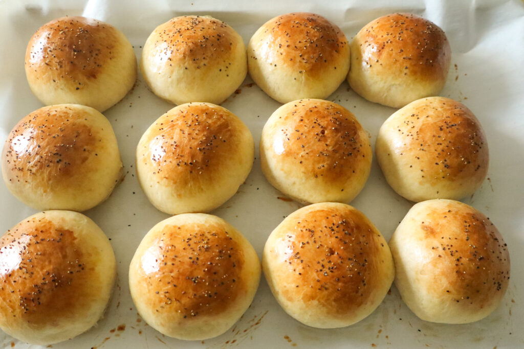 fully cooked burger buns on baking sheet