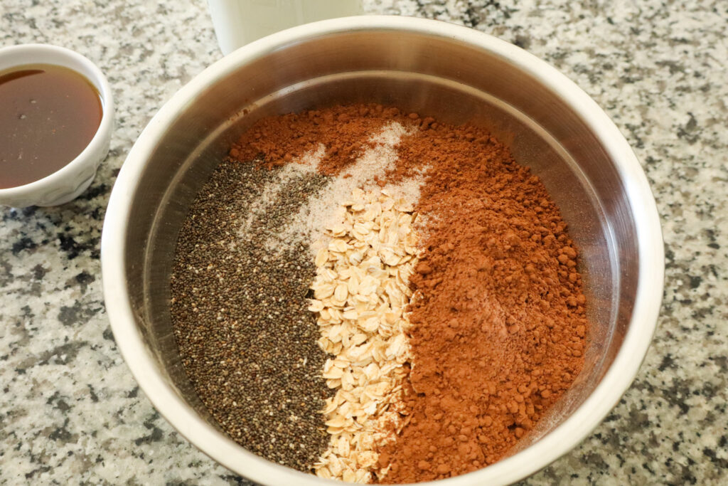 adding dry ingredients to make chocolate overnight oats