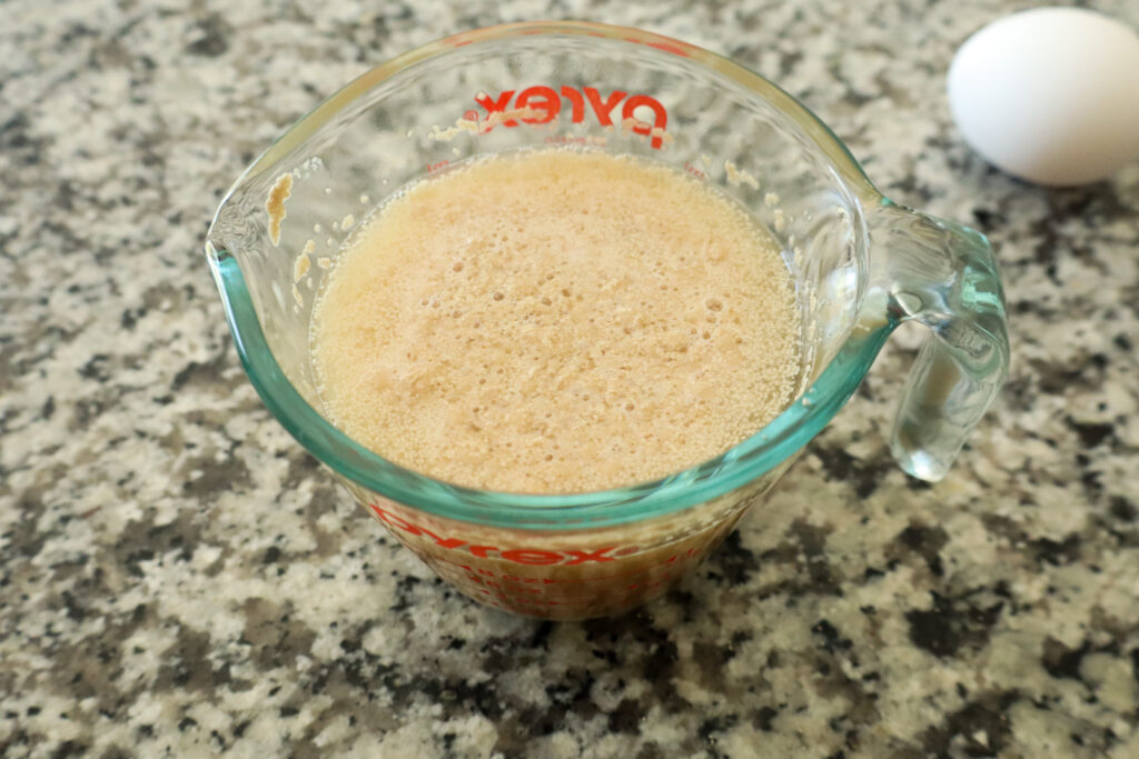 water, honey, and yeast mixed together in measuring cup