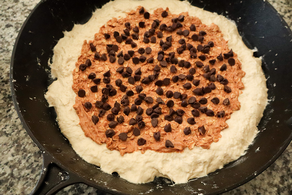 adding chocolate chips to smore's pizza before baking