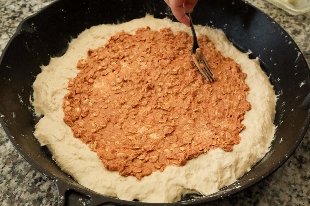 spreading date sugar filling over pizza dough