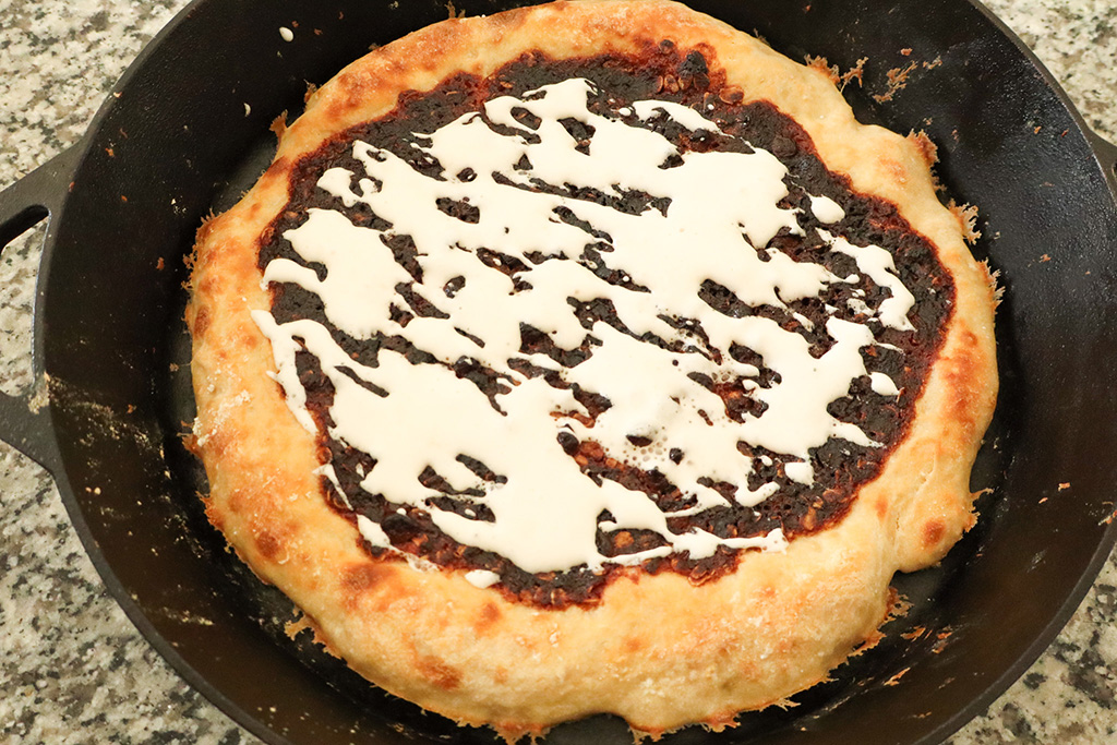 marshmallow fluff drizzled over the top of freshly cooked smore's pizza