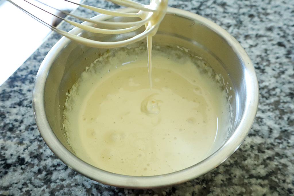 whipped egg yolks dripping off whisk