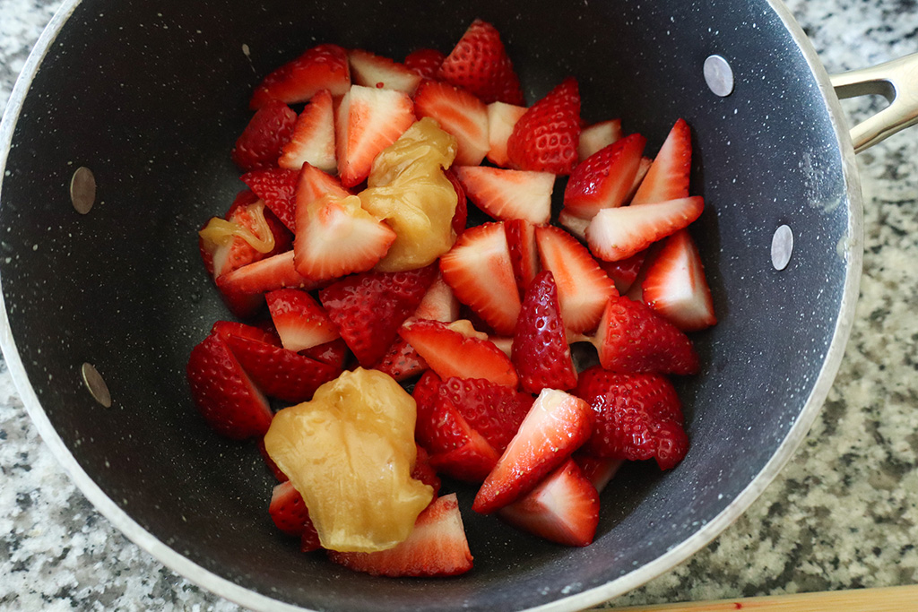quartered strawberries, honey and lemon juice in pot