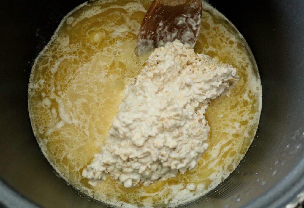 adding yogurt soaked oats to bowl with melted butter, apple juice, honey and yeast
