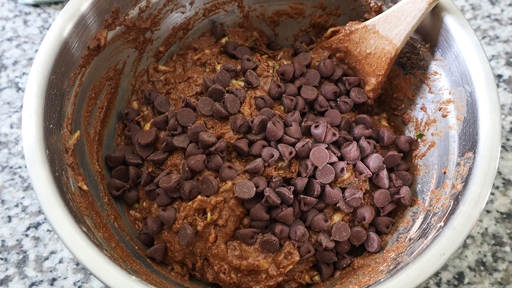 chocolate chips on top of healthy chocolate zucchini muffin batter