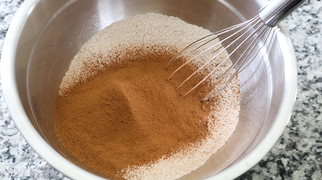 dry ingredients for healthy chocolate zucchini in stainless steel mixing bowl