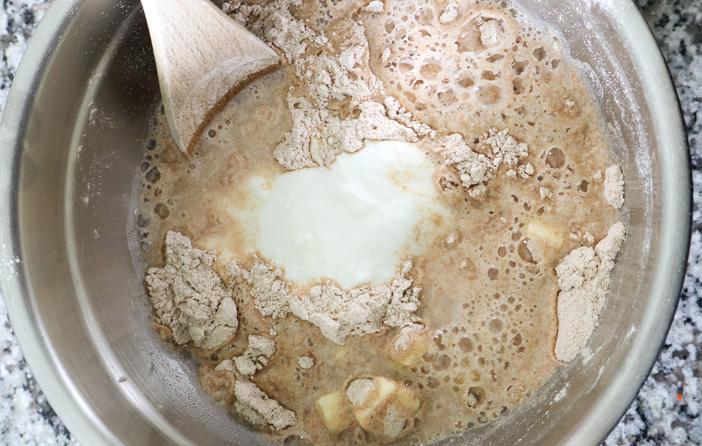 adding wet ingredients to dry ingredients in mixing bowl
